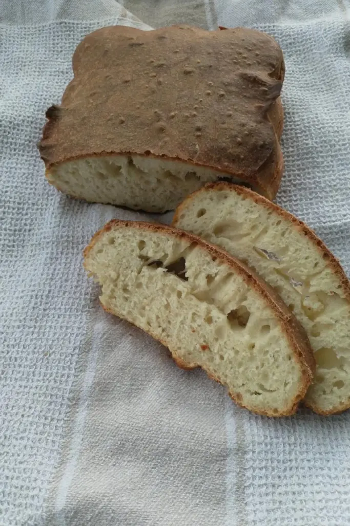 Aufgeschnittenes Sauerteigbrot mit fehlerhafter Krume auf Leinentuch