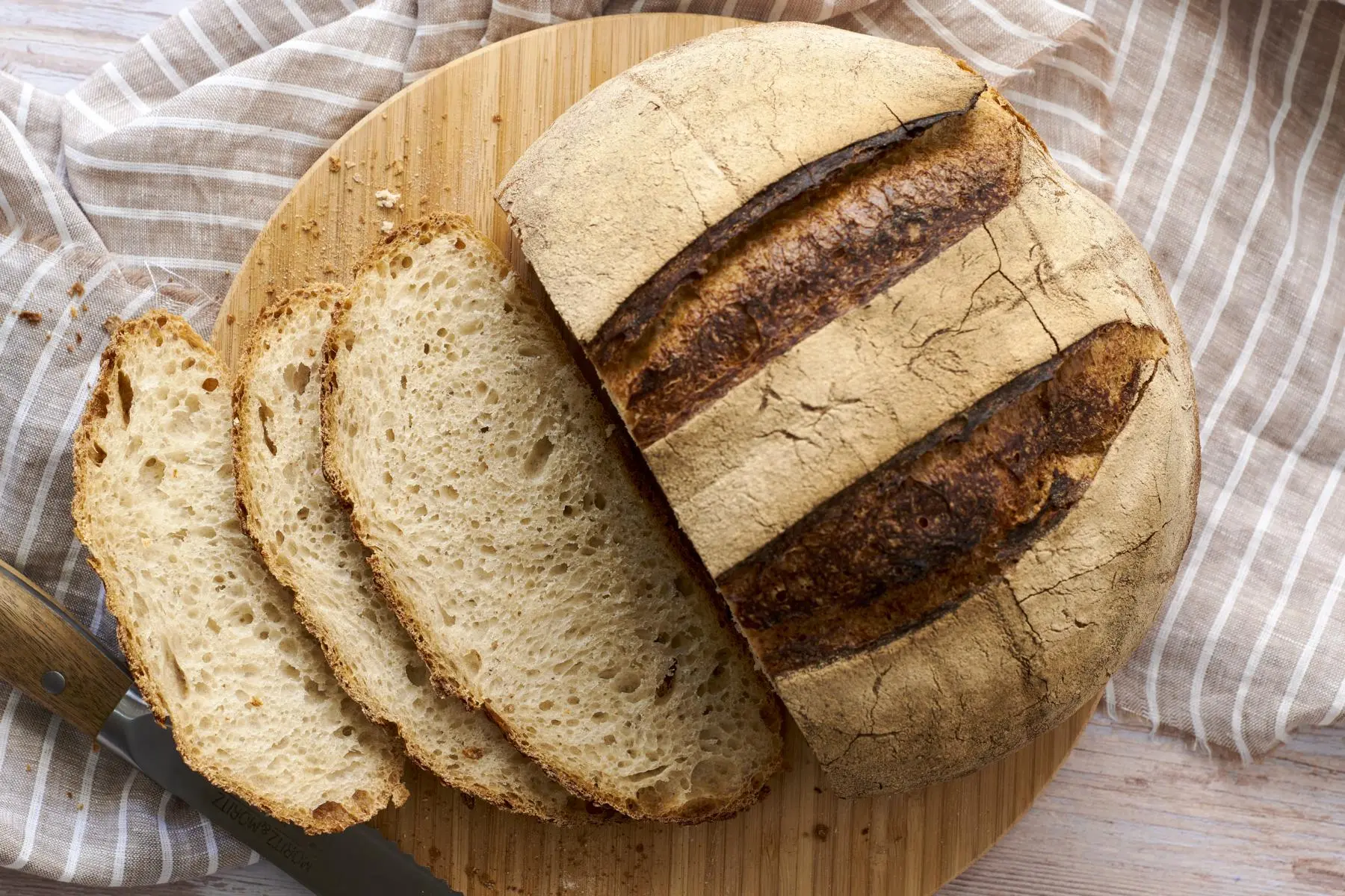 Erstes Sauerteigbrot frisch geschnitten auf Küchentuch