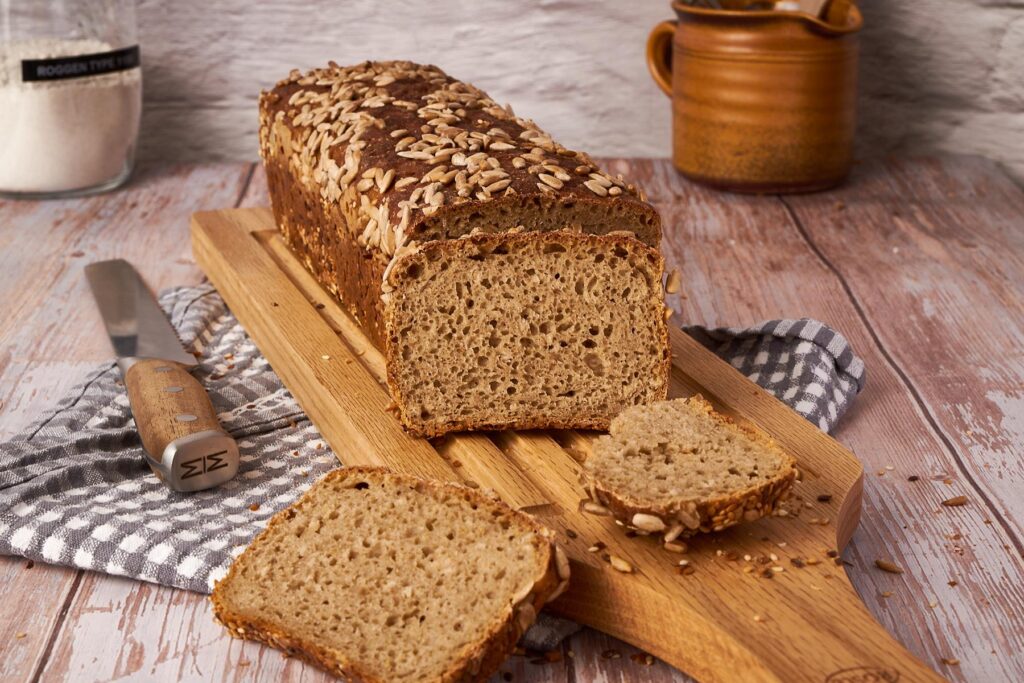 Roggenmischbrot aus Kastenform angeschnitten mit gleichmäßigen Scheiben und Sonnenblumenkernen