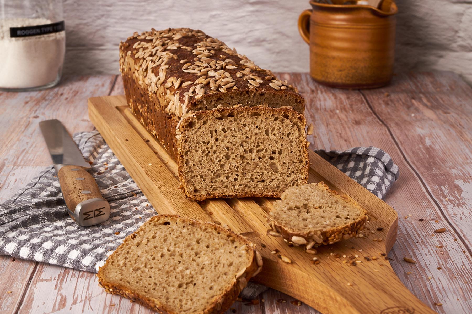 Roggenmischbrot aus Kastenform angeschnitten mit gleichmäßigen Scheiben und Sonnenblumenkernen