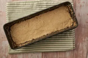 Roggenmischbrot-Teig mit nassen Händen in Kastenform glatt streichen