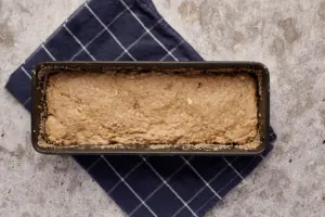 Teigling für saftiges Dinkelvollkornbrot mit Sauerteig in Kastenform vor dem Bestreuen