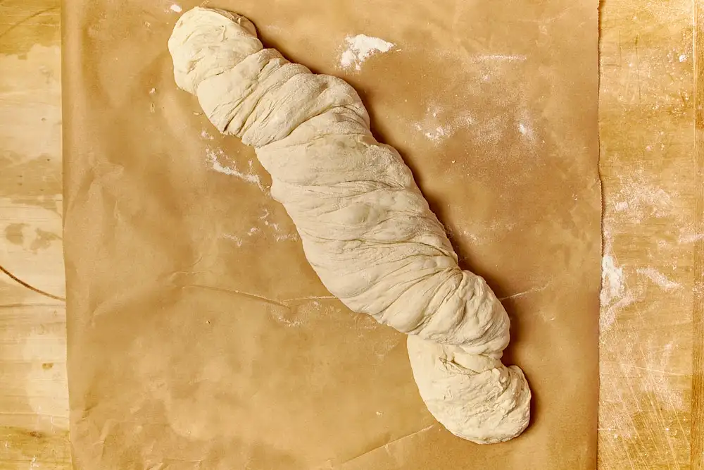 Wurzelbrot Rezept: gezwirbelter Teigling auf Backpapier vor dem Backen