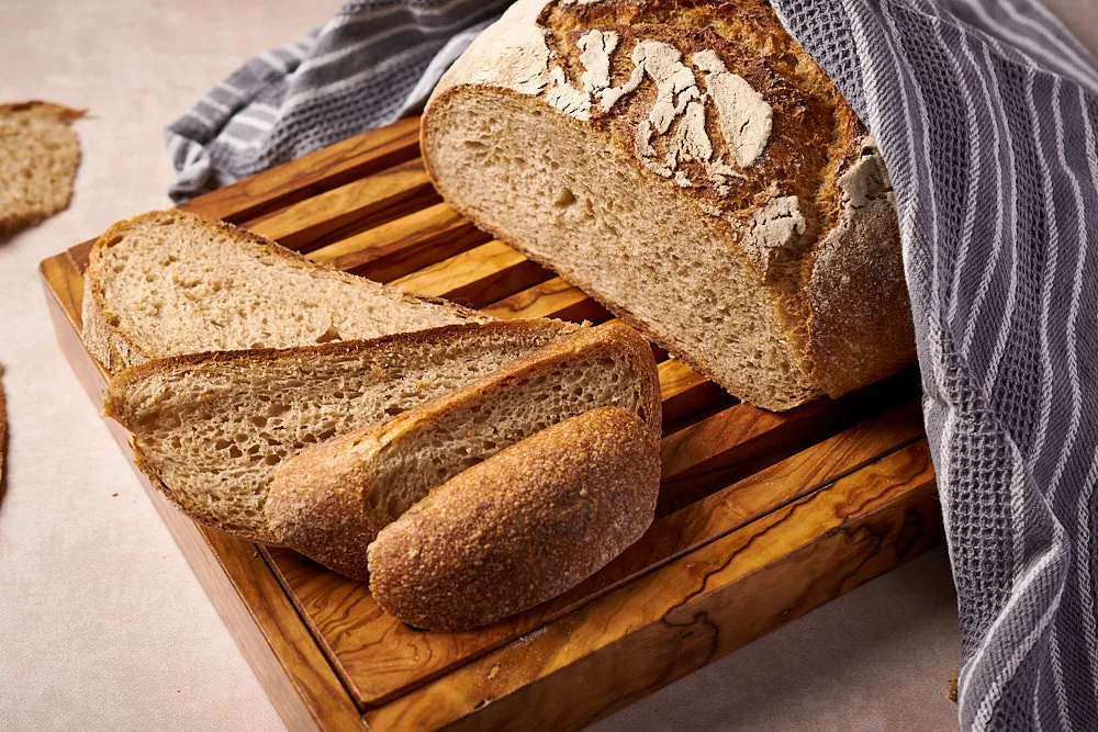 Angeschnittenes Kartoffelbrot mit Sauerteig mit Scheiben auf dem Brett