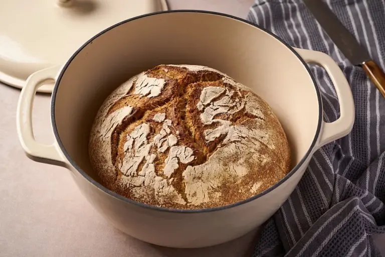 Rundes Kartoffelbrot mit Sauerteig frisch gebacken im gusseisernen Topf