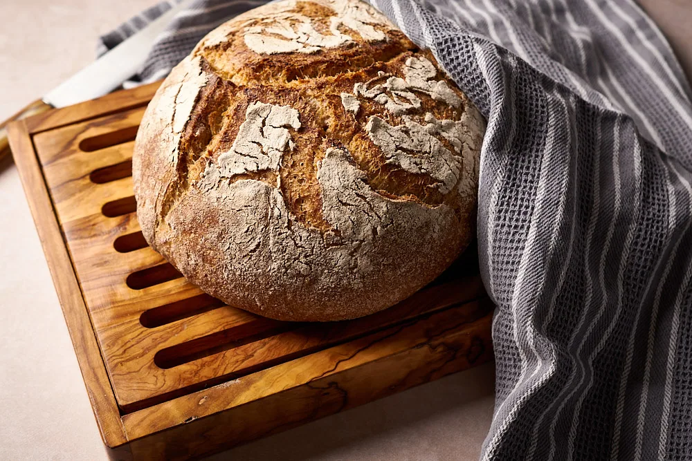 Ganzer Laib Kartoffelbrot mit Sauerteig auf einem Holzbrett