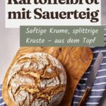 Ganzer Laib Kartoffelbrot mit Sauerteig und aufgerissener Mehlkruste auf einem Holzbrett, daneben ein Messer
