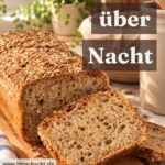 Angeschnittenes Dinkelbrot aus der Kastenform mit Haferflockenkruste auf einem Holzbrett