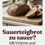 Angeschnittenes Sauerteigbrot mit dunkler Kruste auf einem Holzbrett, daneben zwei Scheiben