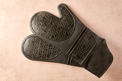 Schwarzer Silikon-Backhandschuh mit Noppenmuster auf hellem Untergrund